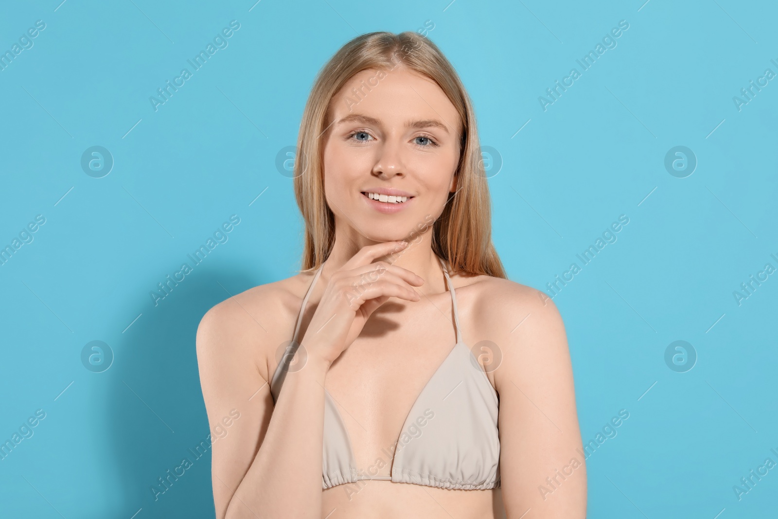 Photo of Beautiful young woman posing on light blue background