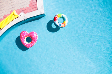Image of Inflatable rings floating in swimming pool, top view with space for text. Summer vacation