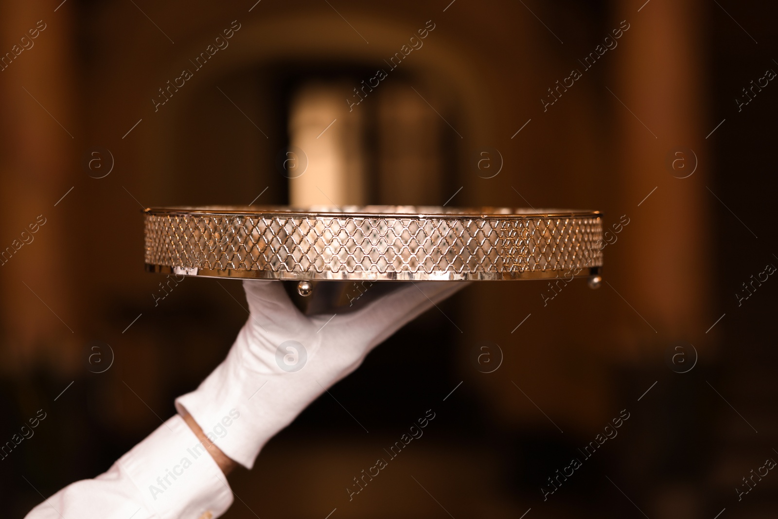 Photo of Butler holding empty tray in restaurant, closeup