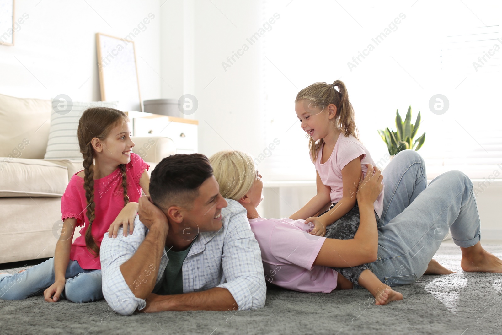 Photo of Happy family with children on floor at home