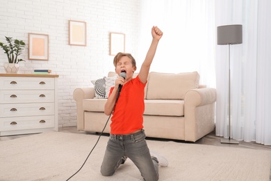 Cute boy singing in microphone at home