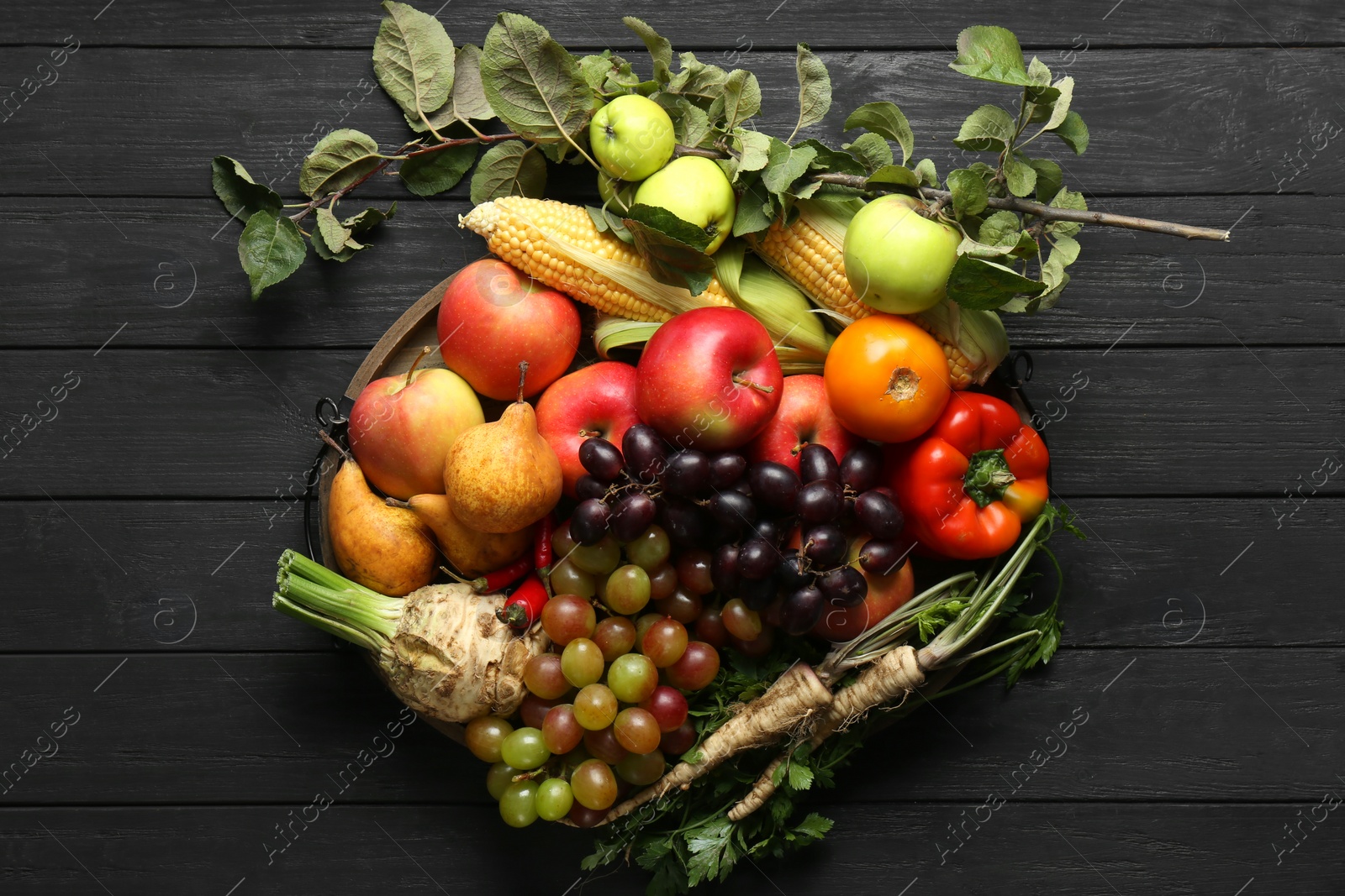 Photo of Different fresh vegetables and fruits on black wooden table, top view. Farmer harvesting