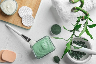Photo of Flat lay composition with spirulina facial mask and ingredients on white table