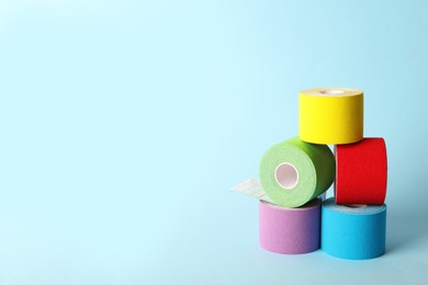 Bright kinesio tape in rolls on light blue background. Space for text