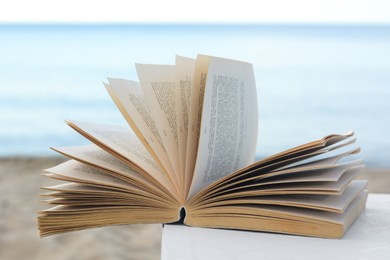 Photo of Open book on white table near sea