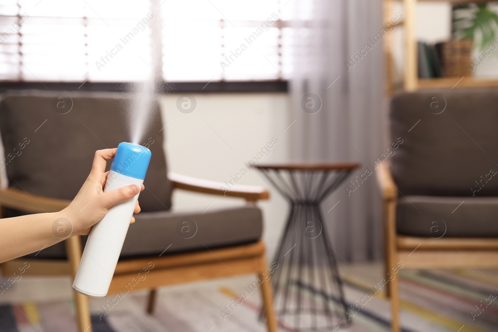 Photo of Woman spraying air freshener at home, closeup