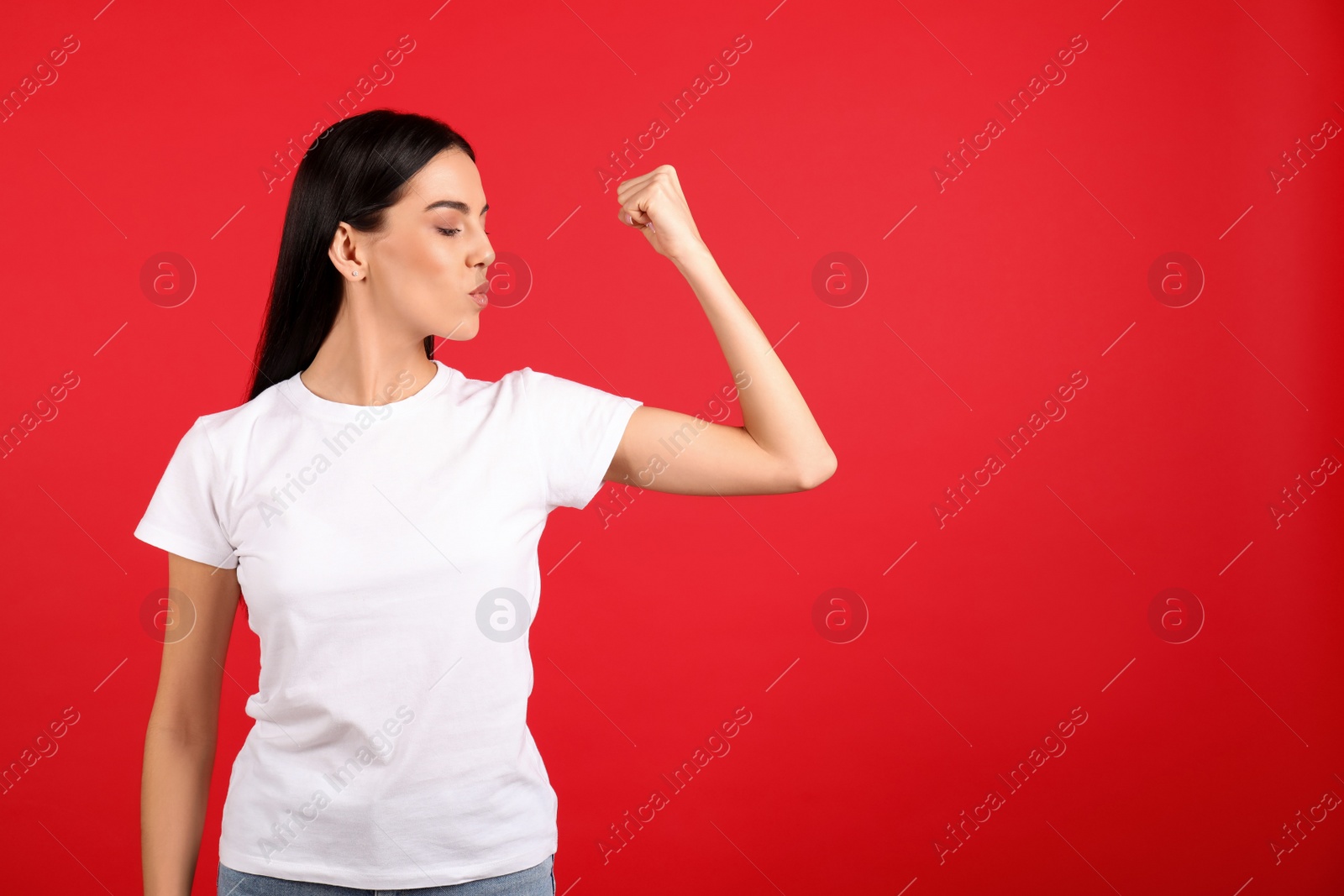 Photo of Strong woman as symbol of girl power on red background, space for text. 8 March concept