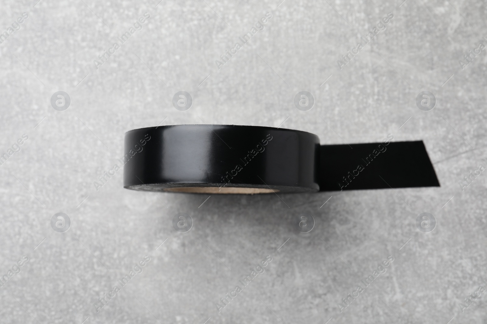 Photo of Black insulating tape on light grey table, top view