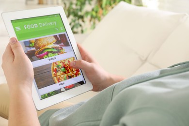 Photo of Man using tablet for ordering food online at home, closeup. Delivery service
