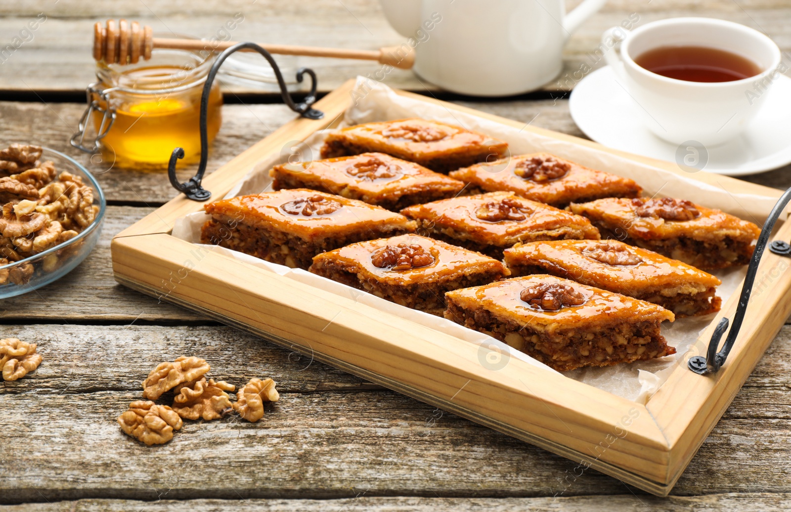 Photo of Delicious sweet baklava with walnuts on wooden table