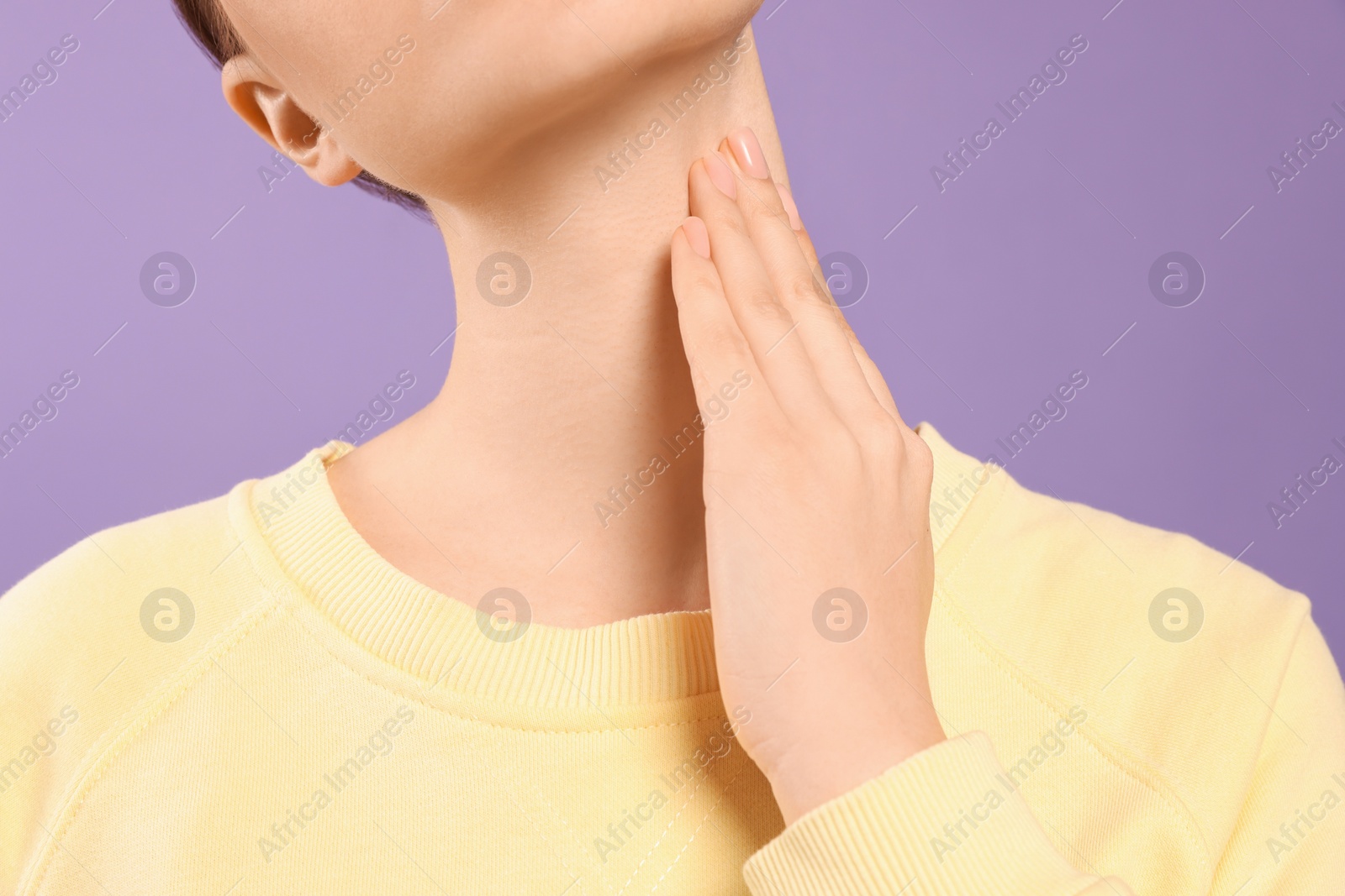 Photo of Woman with sore throat on violet background, closeup