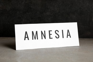 Card with word Amnesia on light grey table