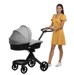 Happy young woman with baby stroller on white background