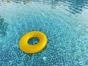 Yellow inflatable ring in swimming pool outdoors