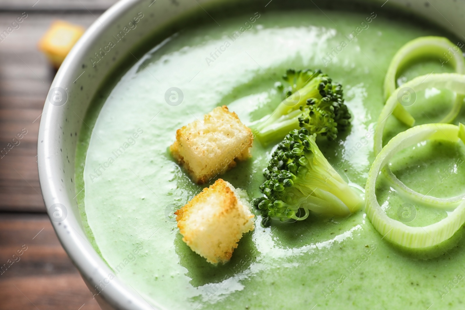 Photo of Fresh vegetable detox soup made of broccoli with croutons in dish, closeup