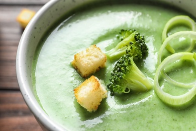 Fresh vegetable detox soup made of broccoli with croutons in dish, closeup