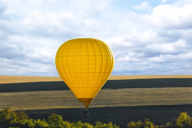 Photo of Colorful hot air balloon flying over field