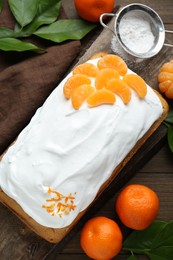 Photo of Delicious homemade yogurt cake with tangerines and cream on wooden table, flat lay