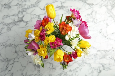 Photo of Beautiful spring freesia flowers on marble background, top view