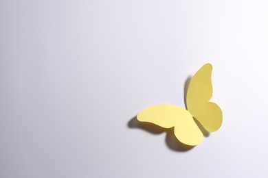 Photo of Yellow paper butterfly on light background, top view. Space for text