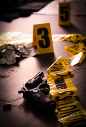Photo of Composition with gun on black slate table, closeup. Crime scene
