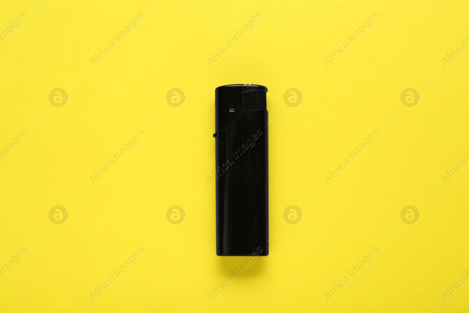 Photo of Stylish small pocket lighter on yellow background, top view