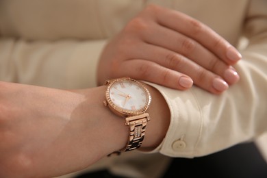 Woman in casual shirt with luxury wristwatch, closeup