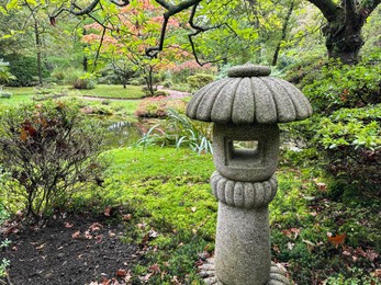 Photo of Stone lantern, different plants and little pond in Japanese garden