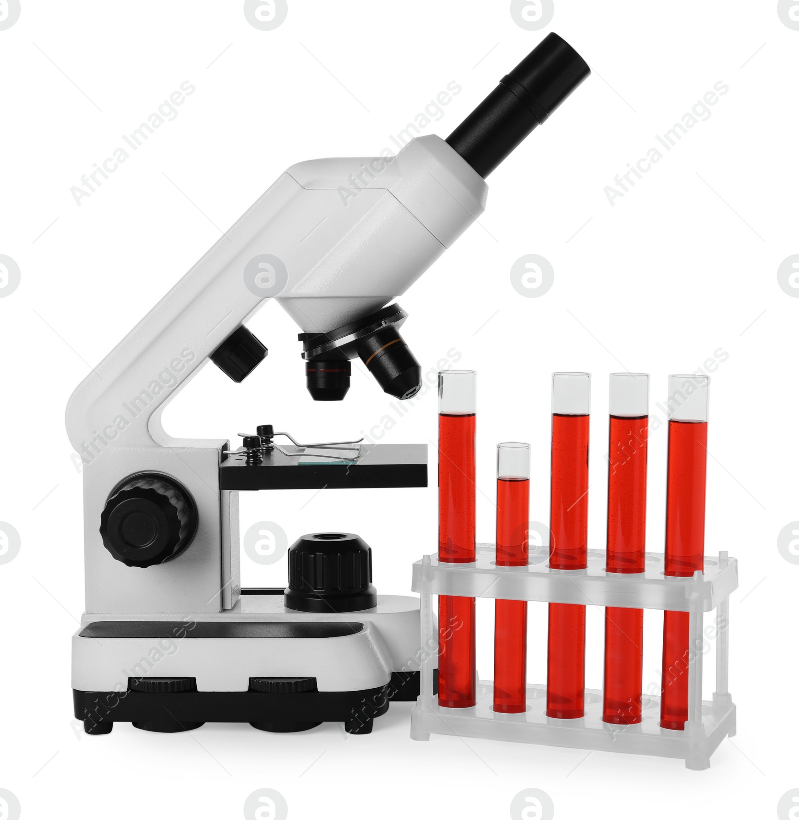 Photo of Test tubes with red liquid and microscope isolated on white