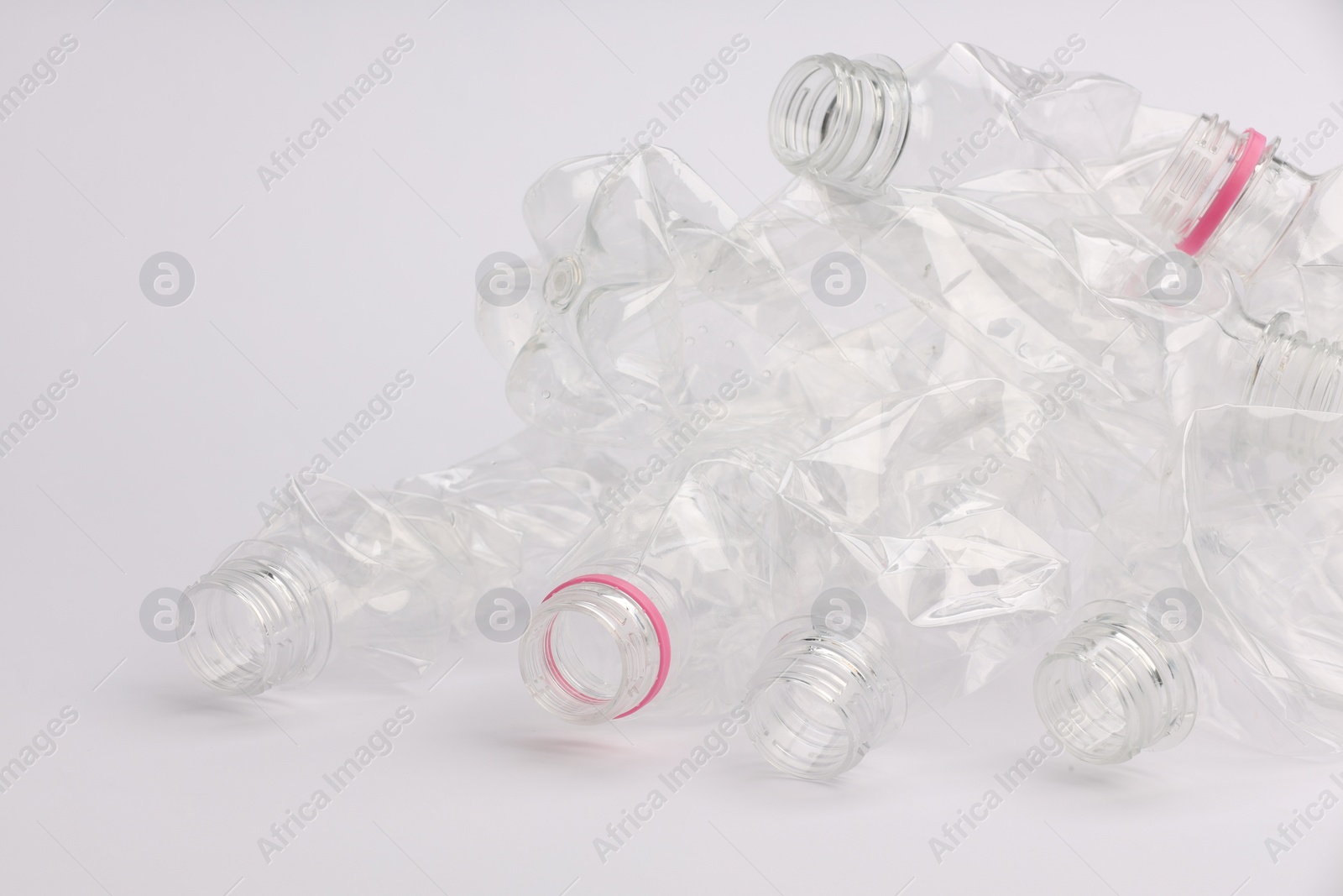 Photo of Crumpled disposable plastic bottles on white background