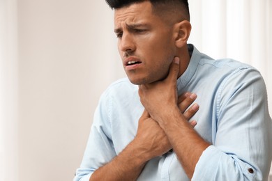 Photo of Man suffering from pain during breathing indoors