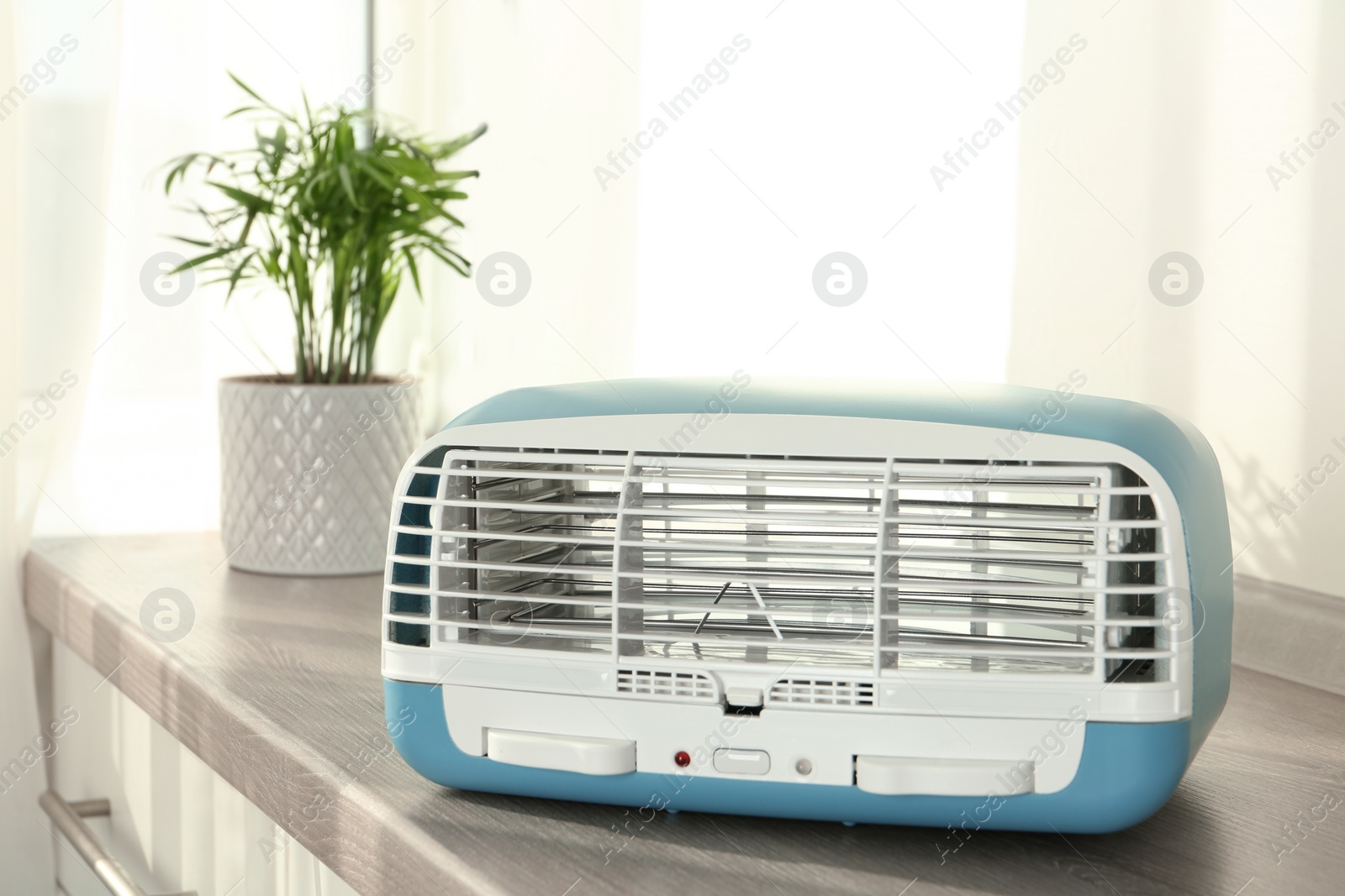 Photo of Stylish ionic air purifier indoors. Modern interior element