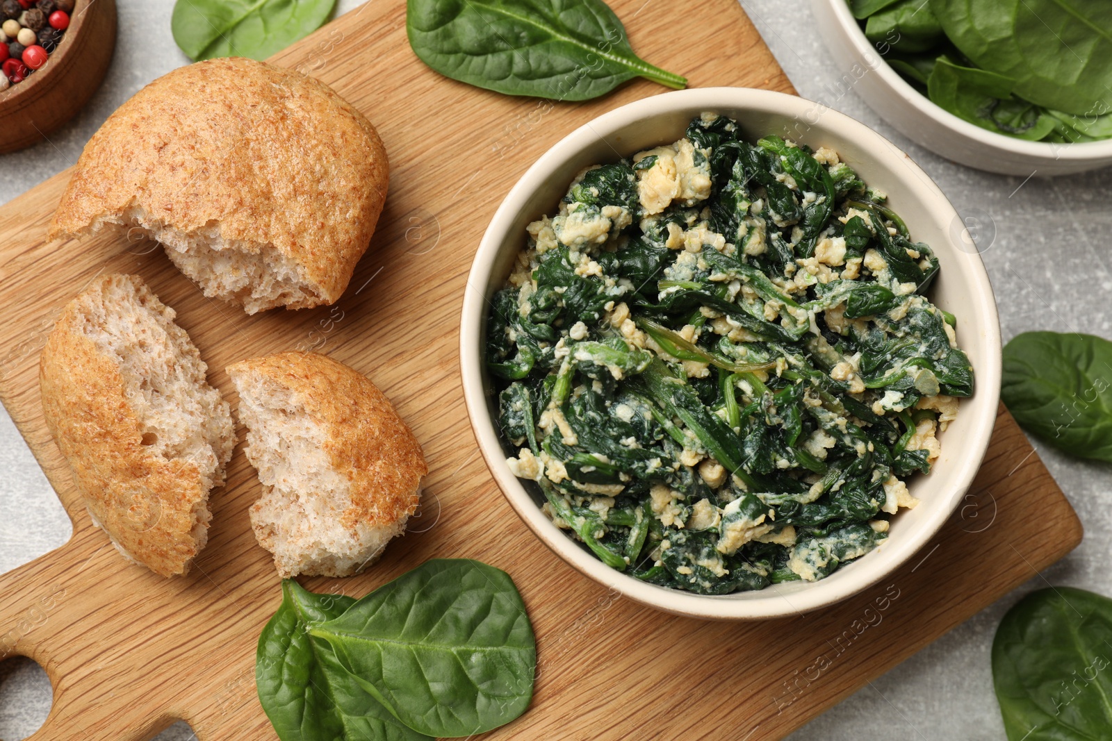 Photo of Tasty spinach dip with egg and bread on grey table, top view