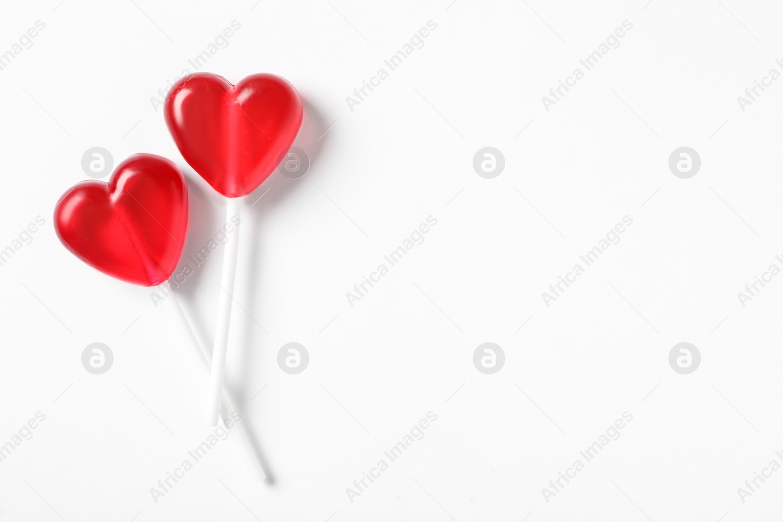 Photo of Sweet heart shaped lollipops on white background, flat lay with space for text. Valentine's day celebration