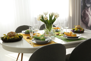 Festive Easter table setting with beautiful white tulips and eggs indoors