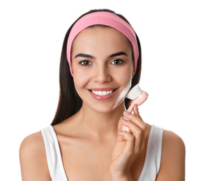 Young woman using facial cleansing brush on white background. Washing accessory