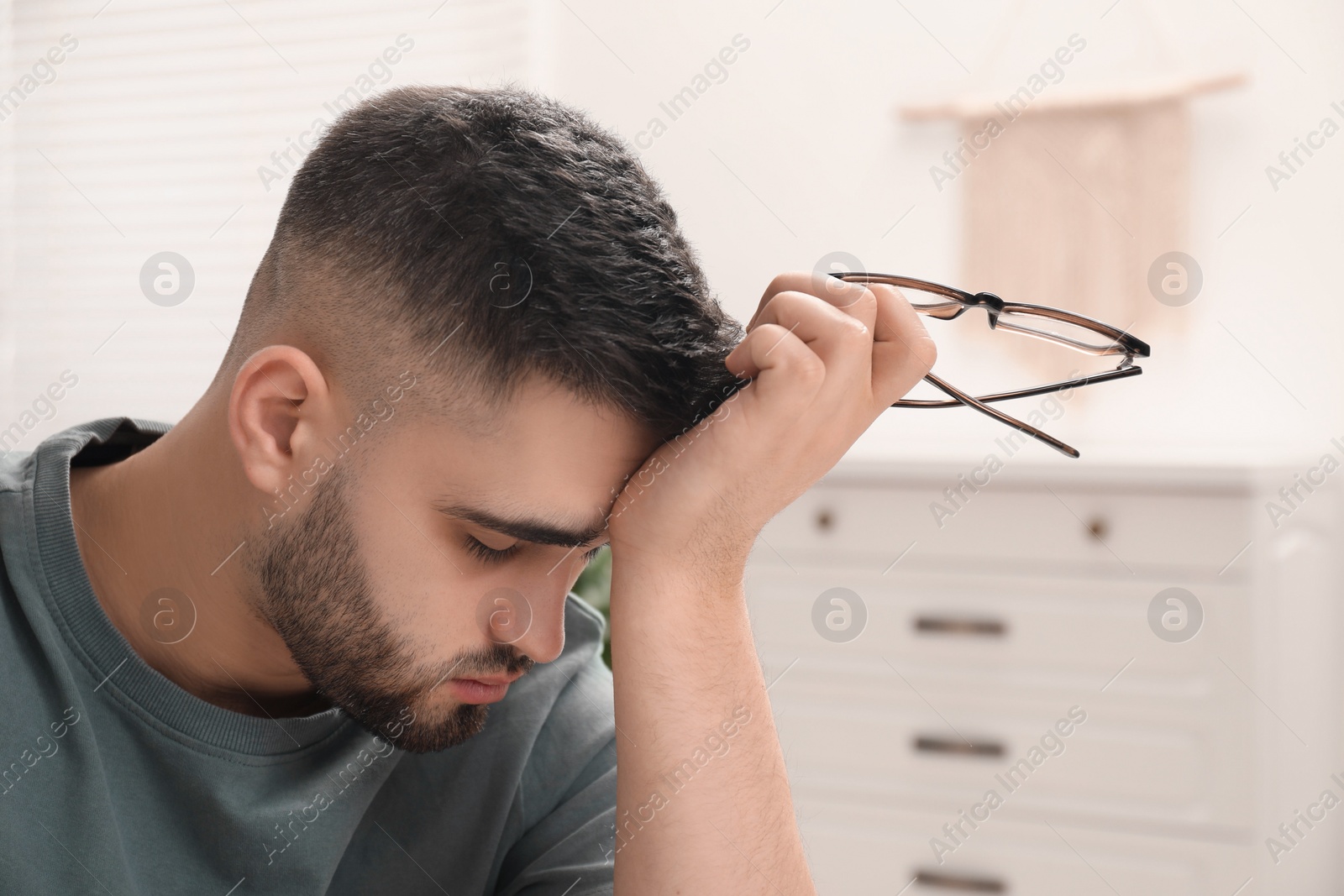 Photo of Portrait of sad man with glasses at home