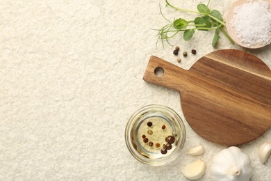 Wooden cutting board and spices on beige table, flat lay. Space for text