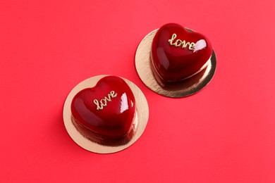 Photo of St. Valentine's Day. Delicious heart shaped cakes on red background, above view