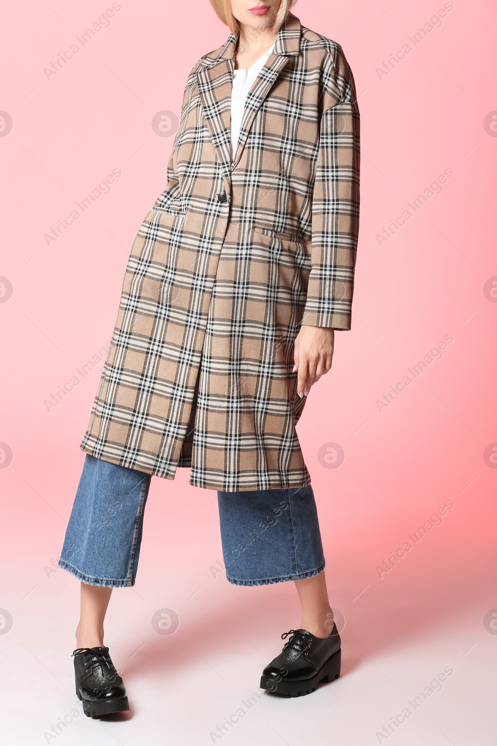 Photo of Fashionable woman in stylish shoes and coat on color background