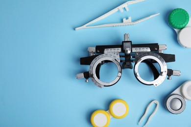 Photo of Different ophthalmologist tools on light blue background, flat lay. Space for text