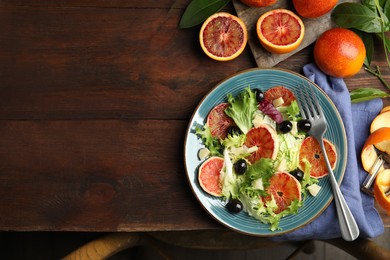 Photo of Delicious sicilian orange salad served on wooden table, flat lay. Space for text