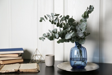 Composition with eucalyptus branches on black table