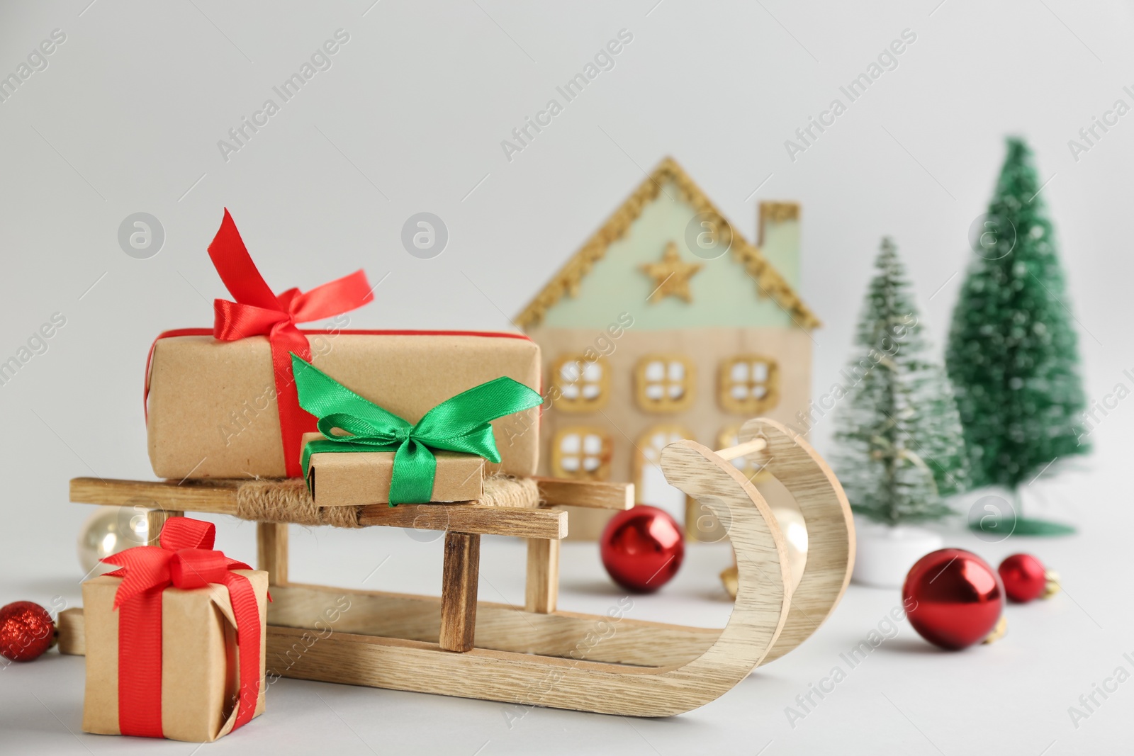 Photo of Beautiful Christmas composition with miniature sleigh on light background