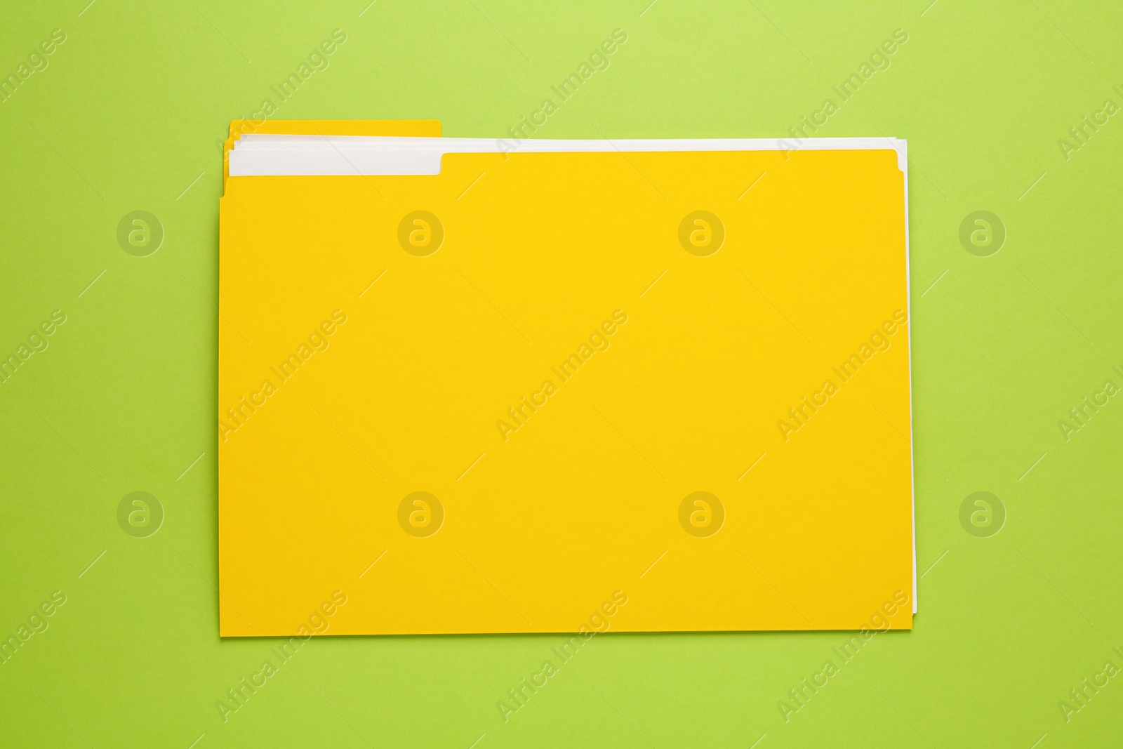 Photo of Yellow file with documents on light green background, top view