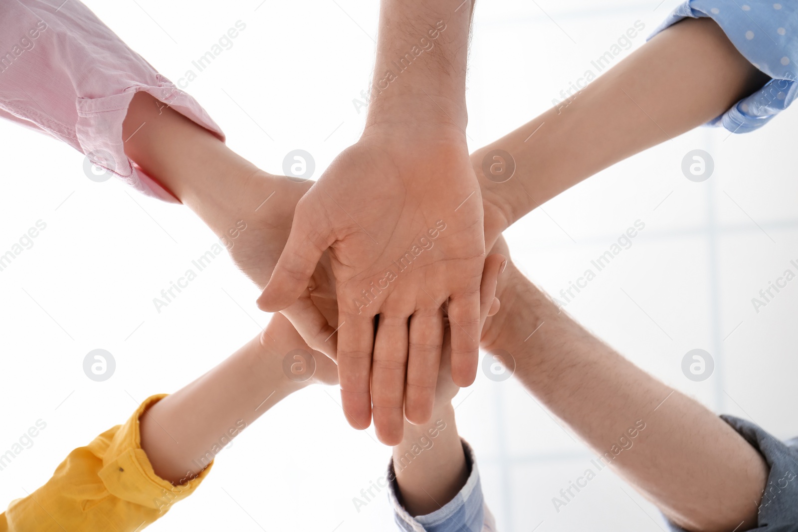 Photo of People holding hands together indoors, bottom view