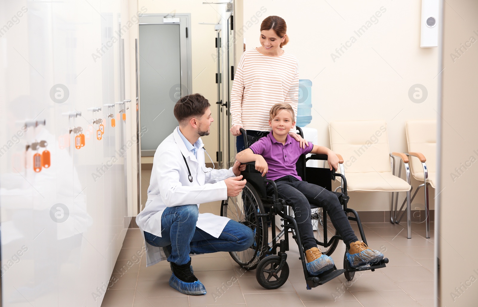 Photo of Doctor with woman and her child in wheelchair at hospital