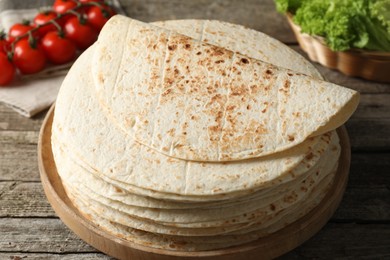 Stack of tasty homemade tortillas on wooden table