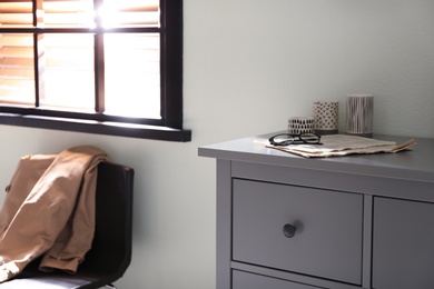 Grey chest of drawers in stylish room interior