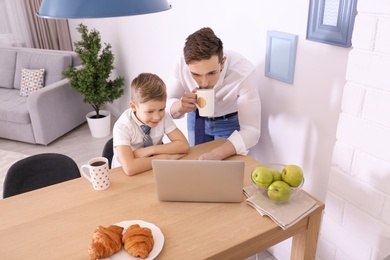 Dad and his son with laptop at home